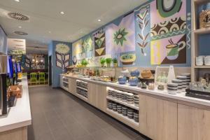 a restaurant with a counter with food on it at Holiday Inn - the niu, Yen Hamburg City by IHG in Hamburg