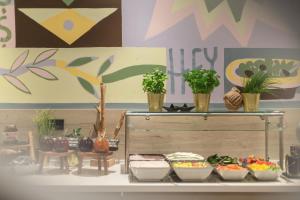 a shelf with bowls of food and potted plants on it at Holiday Inn - the niu, Yen Hamburg City by IHG in Hamburg