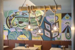 a chandelier in a restaurant with a colorful wall at Holiday Inn - the niu, Yen Hamburg City by IHG in Hamburg