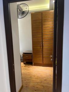 カイロにあるprivate room in shared apartment New Cairoのクローゼット、扇風機、木の床のある部屋