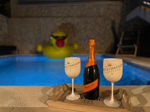 une bouteille de vin sur un plateau à côté de deux verres dans l'établissement Ferienwhg Bilice 1 - Pool beheizt - Fitness - Relax, à Bilice
