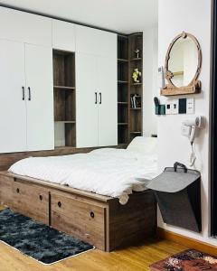 a bed in a room with white cabinets and a mirror at Tom's Homestay in Ho Chi Minh City