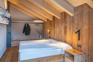 a bedroom with a bed and a wooden wall at LIVIN JOY Bivio Travel in Livigno