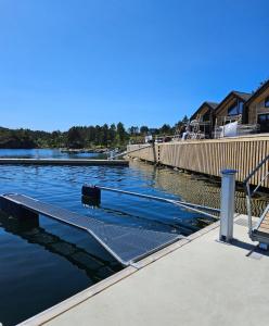 een dok met een bank naast een waterlichaam bij Eksklusiv hytte i skjærgården! in Austevoll