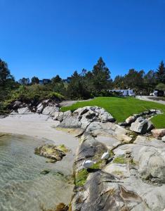 een uitzicht op een strand met rotsen en de oceaan bij Eksklusiv hytte i skjærgården! in Austevoll