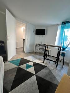 a living room with a table and a table at Studio Cozy proche aéroport CDG in Claye-Souilly