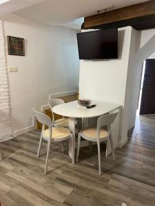 a white table and chairs with a tv on the wall at CASA 1860 CANDELEDA in Candeleda