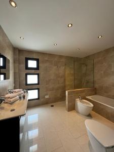 ein Badezimmer mit Badewanne, Toilette und Waschbecken in der Unterkunft Nazaret Home in Nazaret