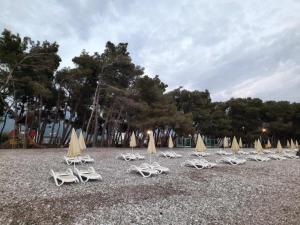 a group of lounge chairs and umbrellas on a beach at Šušanj Ilino APARTMAN in Bar