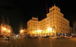 un grand bâtiment avec des voitures garées devant lui la nuit dans l'établissement Hotel Chanel Apartments, à Tbilissi