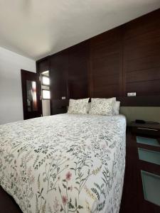 a bedroom with a large bed with a floral bedspread at Nazaret Home in Nazaret +51 photos