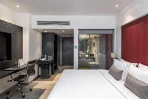 a bedroom with a bed and a desk and a computer at Hotel Suncity Residency in Mumbai