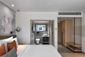 a bedroom with a white bed and a bathroom at Hotel Suncity Residency in Mumbai