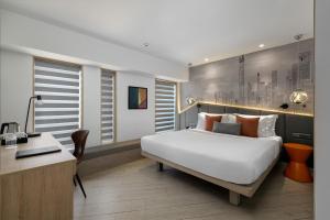 a bedroom with a large white bed and a desk at Hotel Suncity Residency in Mumbai