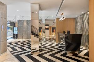 a lobby with a black and white patterned floor at Hotel Suncity Residency in Mumbai