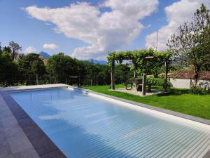 a large swimming pool in a yard with a garden at Casa Alla Vigna - Lugano in Pregassona