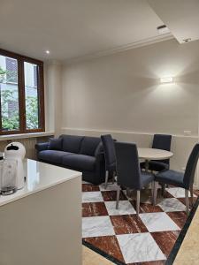 a living room with a couch and a table and chairs at Andreola Central Hotel in Milan