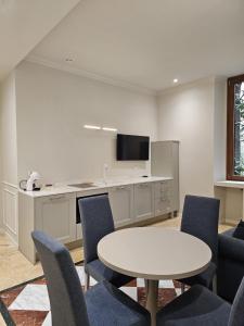 a room with a table and chairs and a kitchen at Andreola Central Hotel in Milan