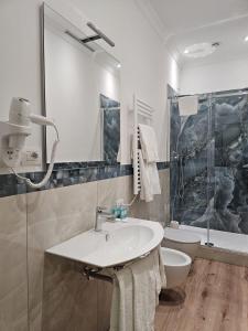 a white bathroom with a sink and a toilet at Andreola Central Hotel in Milan