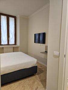 a bedroom with a bed and a flat screen tv at Andreola Central Hotel in Milan