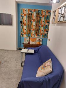 a room with a blue bed and a table at Dimoranna Casa Vacanza con Parcheggio Privato in Pizzo +24 photos
