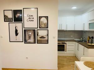 a white kitchen with pictures on the wall at Apartman Hana2 in Sombor