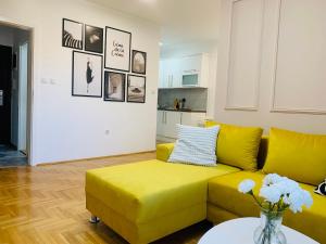 a living room with a yellow couch and a table at Apartman Hana2 in Sombor