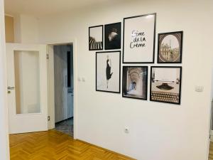 a gallery wall with pictures on a white wall at Apartman Hana2 in Sombor