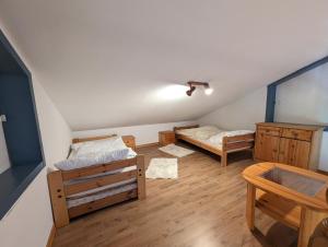 a attic room with two beds and a table at Landhaus Oldorf in Rodenäs