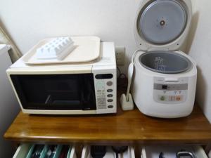 a microwave and a toaster oven sitting on a shelf at Farm Inn Minamiboso in Minamiboso