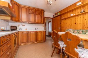 a kitchen with wooden cabinets and a table and chairs at Lodge Auta in Falcade +17 photos