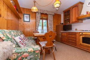 a living room with a couch and a kitchen at Lodge Auta in Falcade