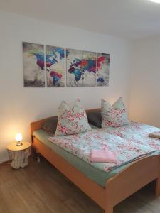 a bed in a room with three paintings on the wall at Appartement in Gelsenkirchen in Gelsenkirchen