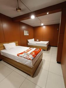 two beds in a room with brown walls at Dream Vision Guest House in Diu