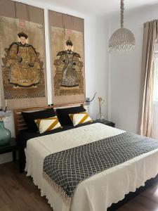 a bedroom with a bed and paintings on the wall at Apartamento con Parking El Rincón del Arte Granada Centro in Granada