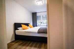 パーダーボルンにあるYellow Stationのベッドルーム1室(オレンジ色の枕が付いたベッド1台付)