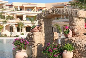 a large stone building with a statue of a woman in front of it at Aphrodite Sands Resort in Mandria