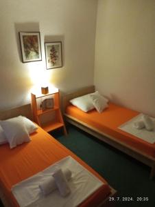 two beds in a hotel room with towels on them at Vacanza apartment in Mostar