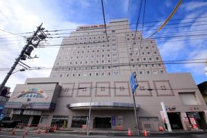 a tall building with orange cones in front of it at Kofu Washington Hotel Plaza in Kofu