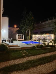 - une piscine avec une table de pique-nique la nuit dans l'établissement Sunny apartments, à Ulcinj