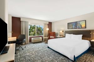 a hotel room with a large white bed and a desk at Hilton Garden Inn San Mateo in San Mateo