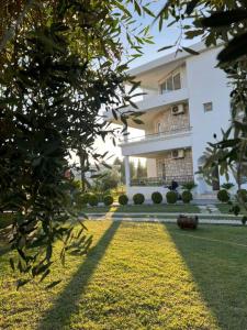 un grand bâtiment blanc avec une pelouse devant lui dans l'établissement Sunny apartments, à Ulcinj