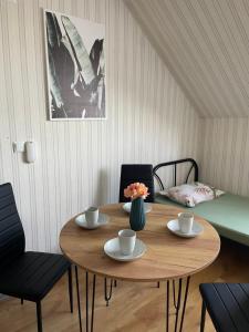 a wooden table with two cups and a vase with flowers at VIP hostel in Mukacheve