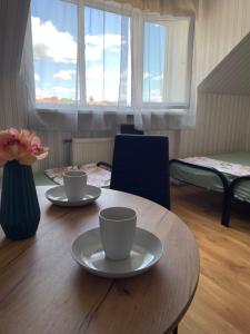 a table with two cups and a vase with flowers at VIP hostel in Mukacheve +44 photos