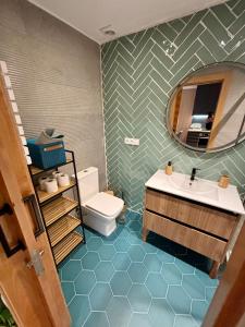 a bathroom with a sink and a toilet and a mirror at Lugar de Alegría, Pegado a Playa, 2 Hab, 6 p, Wifi - VUT-4241-AS in Gijón