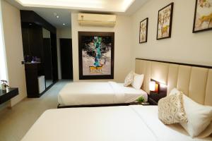 Postel nebo postele na pokoji v ubytování Hotel Grand Visava Lonavala