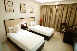Postel nebo postele na pokoji v ubytování Hotel Grand Visava Lonavala