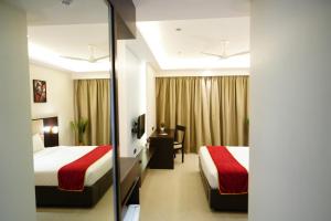 Postel nebo postele na pokoji v ubytování Hotel Grand Visava Lonavala