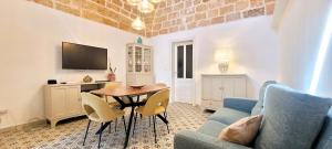 a living room with a table and chairs and a tv at Villa Pestanaca in Tiggiano