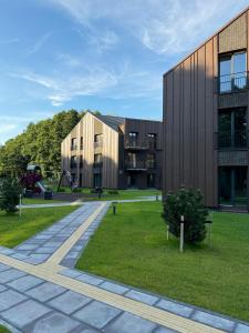 ein Gebäude mit einem Spielplatz vor einem Park in der Unterkunft Nauji apartamentai Palangoje Nemirsetos parke in Palanga